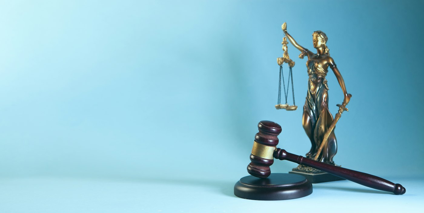 law theme, mallet of the judge and scales of justice on a blue background
